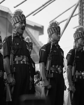 Black and white photo of soldiers in uniform during a ceremonial parade outdoors.