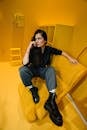 A Shot of Female Looking Away While Sitting on Yellow Armchair