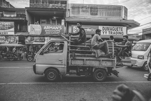 A candid street view of men on a truck in Dumaguete city, Philippines, highlighting urban life.