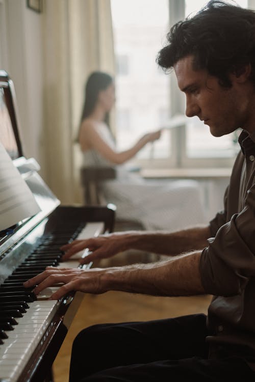 Free Side View of a Man Playing a Grand Piano Stock Photo