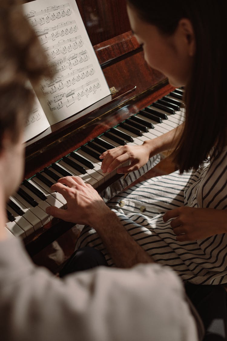 Man And Woman Playing The Piano Together