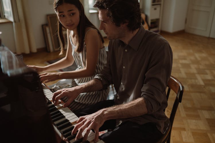 Man And Woman Playing A Piano Together