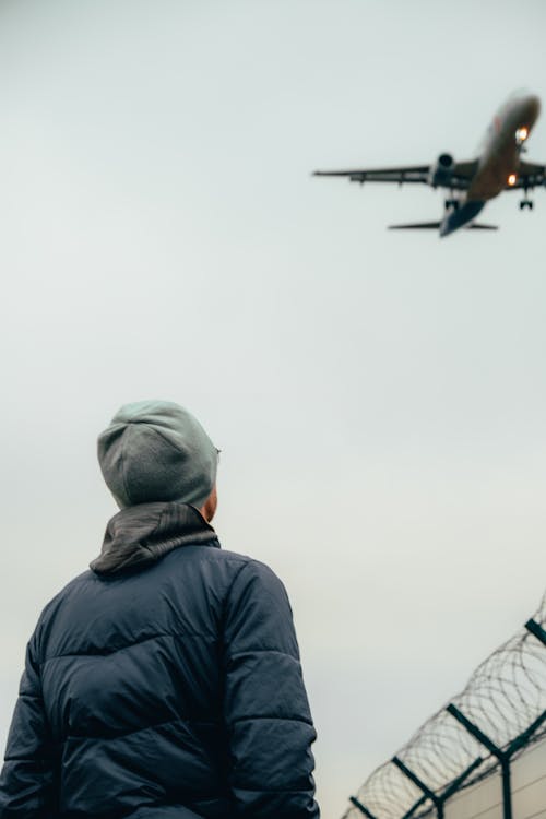 Person Looking at  an Airplane in the Sky