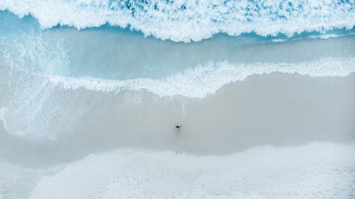 Drone Shot of a Person Standing on Shore