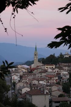 Picturesque view of an Italian village with a central clock tower at dusk. — photo by Matteo Milan