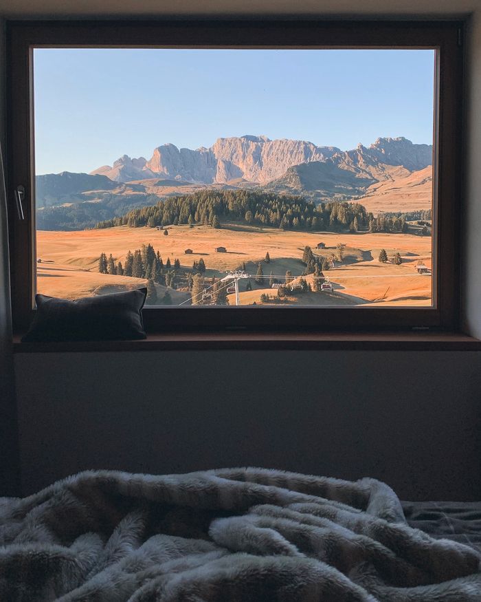 Mountain and field landscape behind a bedroom window