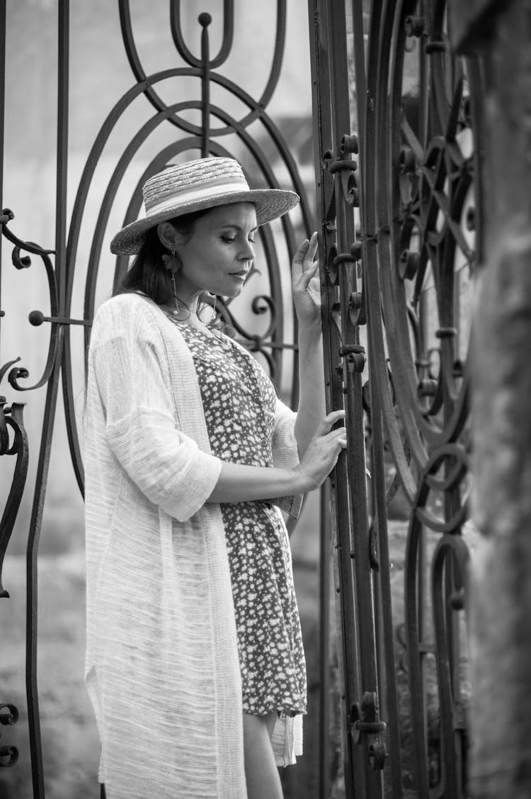 Woman In Hat Standing By Gate