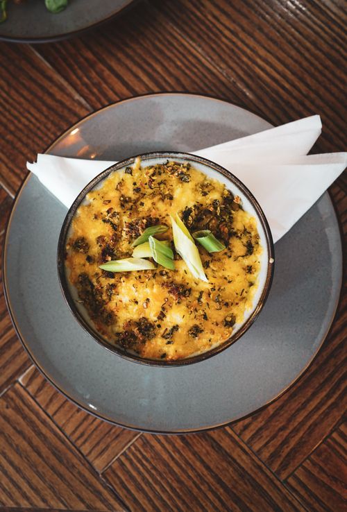 Free A delicious cheesy baked dish garnished with green onions, shot from above on a wooden table. Stock Photo