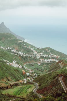 Captivating view of lush green hills leading to the ocean in Santa Cruz de Tenerife, Spain.
