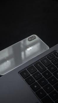 Minimalist setup featuring a smartphone and laptop keyboard in soft, natural light.