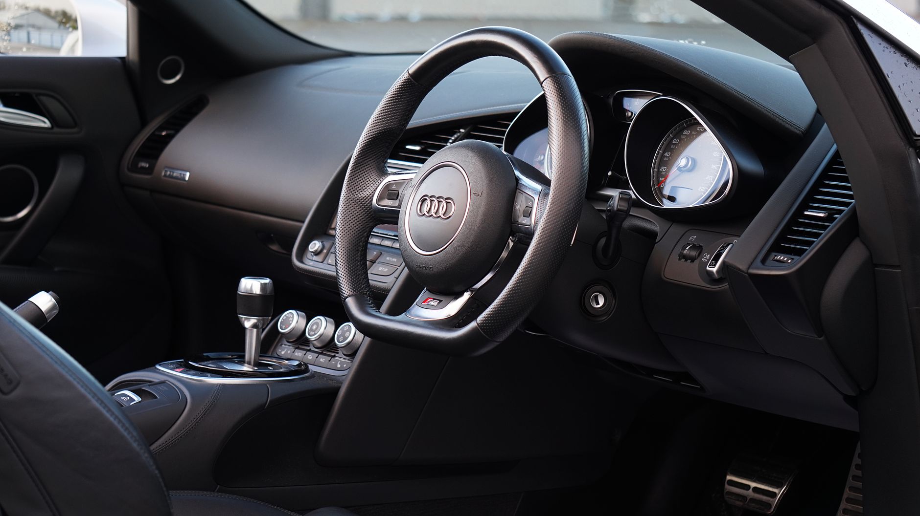 Explore the sleek interior design of the Audi R8 sports car, featuring a stylish steering wheel and dashboard.