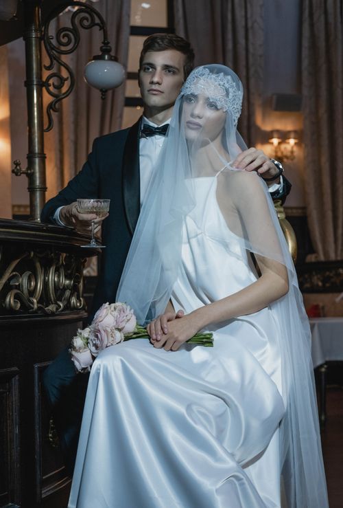 Free Stylish couple's wedding portrait with elegant attire in upscale indoor setting. Stock Photo