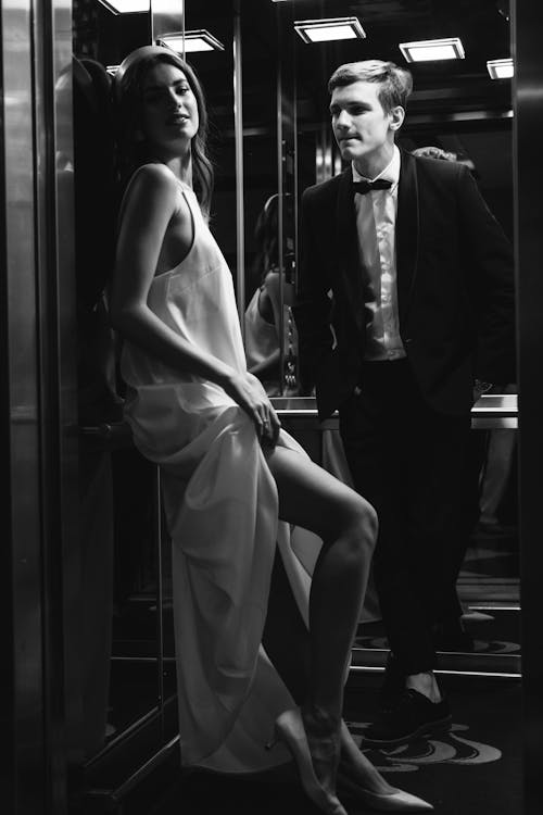 Grayscale Photo of Man and Woman in the Elevator