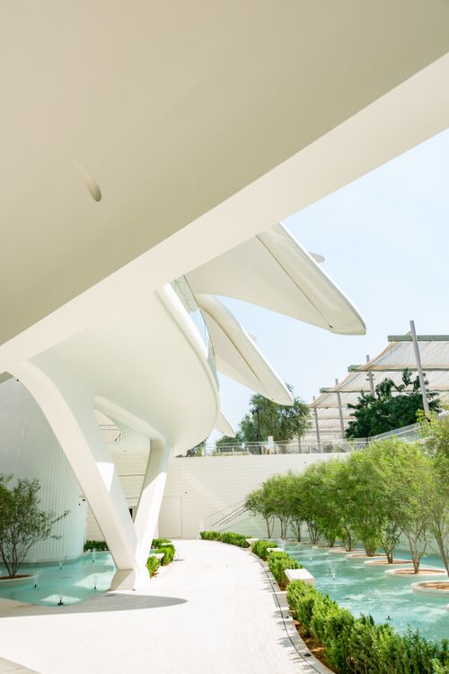 Free Explore futuristic architecture surrounded by lush greenery and tranquil water features. Stock Photo