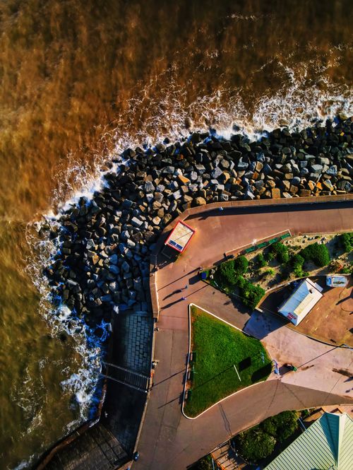 Free Aerial view of a rocky coastline pathway with waves in England, showcasing natural beauty. Stock Photo