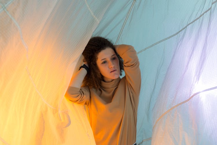 A Woman In Brown Long Sleeves Inside A Tent