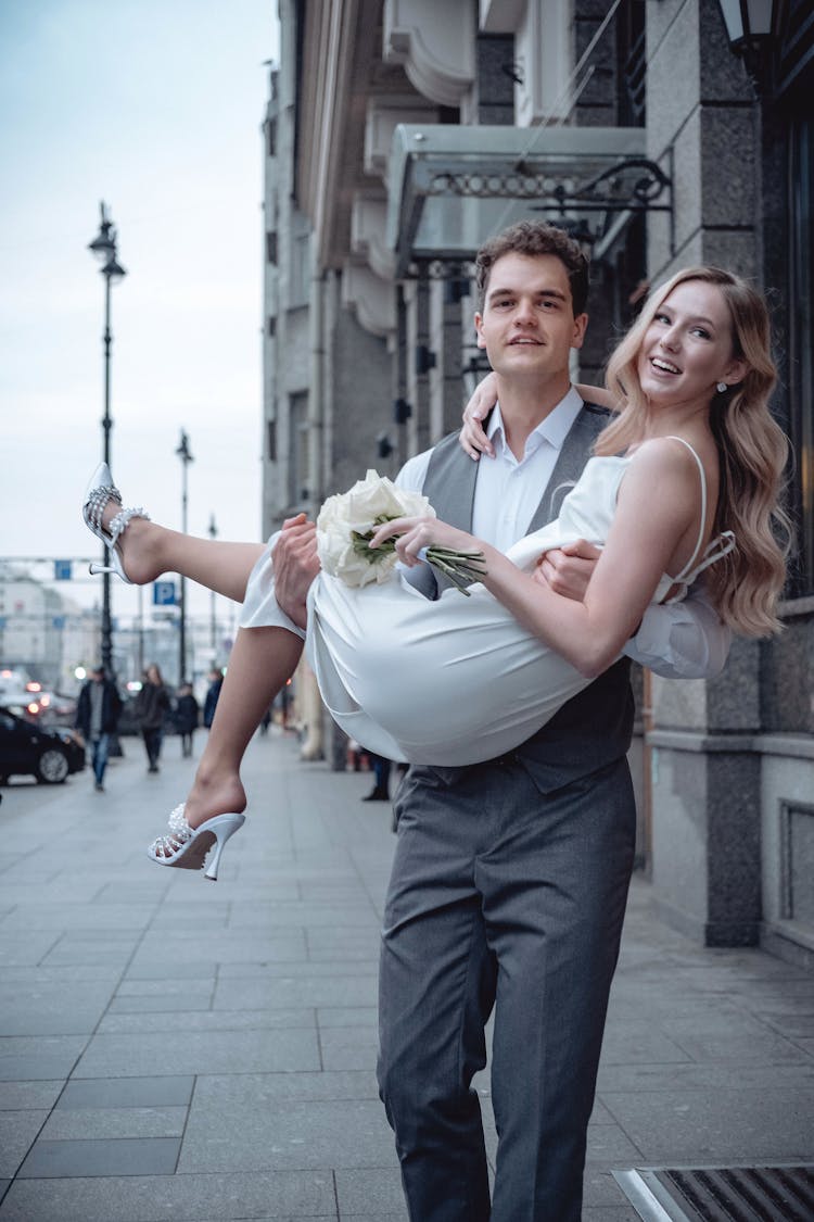 Man Carrying Woman In Wedding Dress