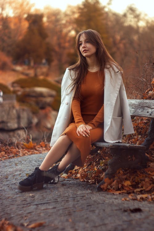 Woman in Dress Sitting on Wooden Bench
