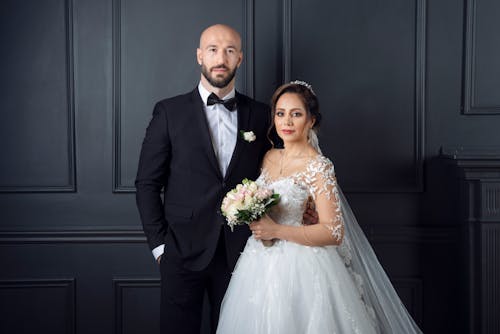 Woman in Wedding Gown Standing Beside a Man