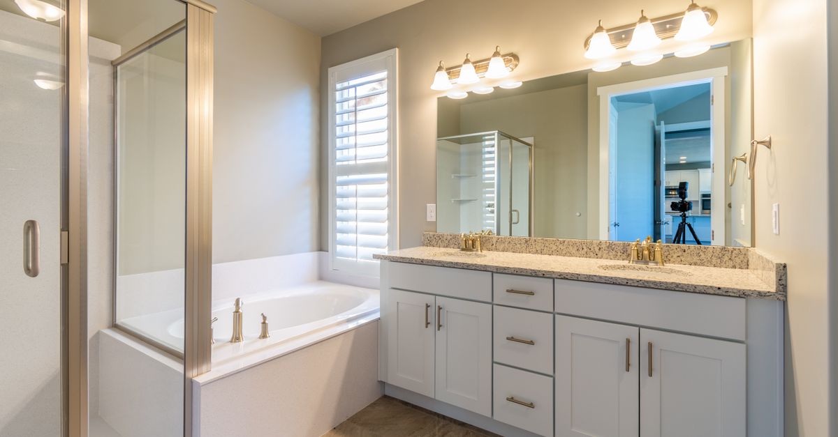 Bright modern bathroom featuring a shower, bathtub, and dual sink vanity.