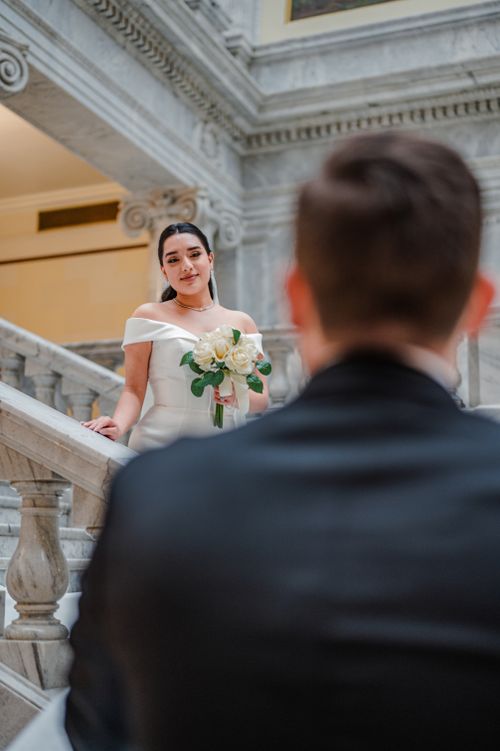 Free Bride and groom elegantly posing on a marble staircase, exuding romance and elegance. Stock Photo