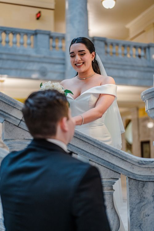 Free Bride and groom sharing a moment on elegant marble staircase indoors. Stock Photo