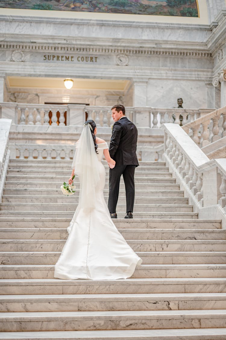 Newlywed Couple Walking Up The Grand Staircase