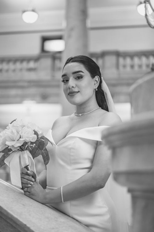 Free A graceful bride in a wedding dress holding a bouquet, captured in a timeless monochrome setting. Stock Photo