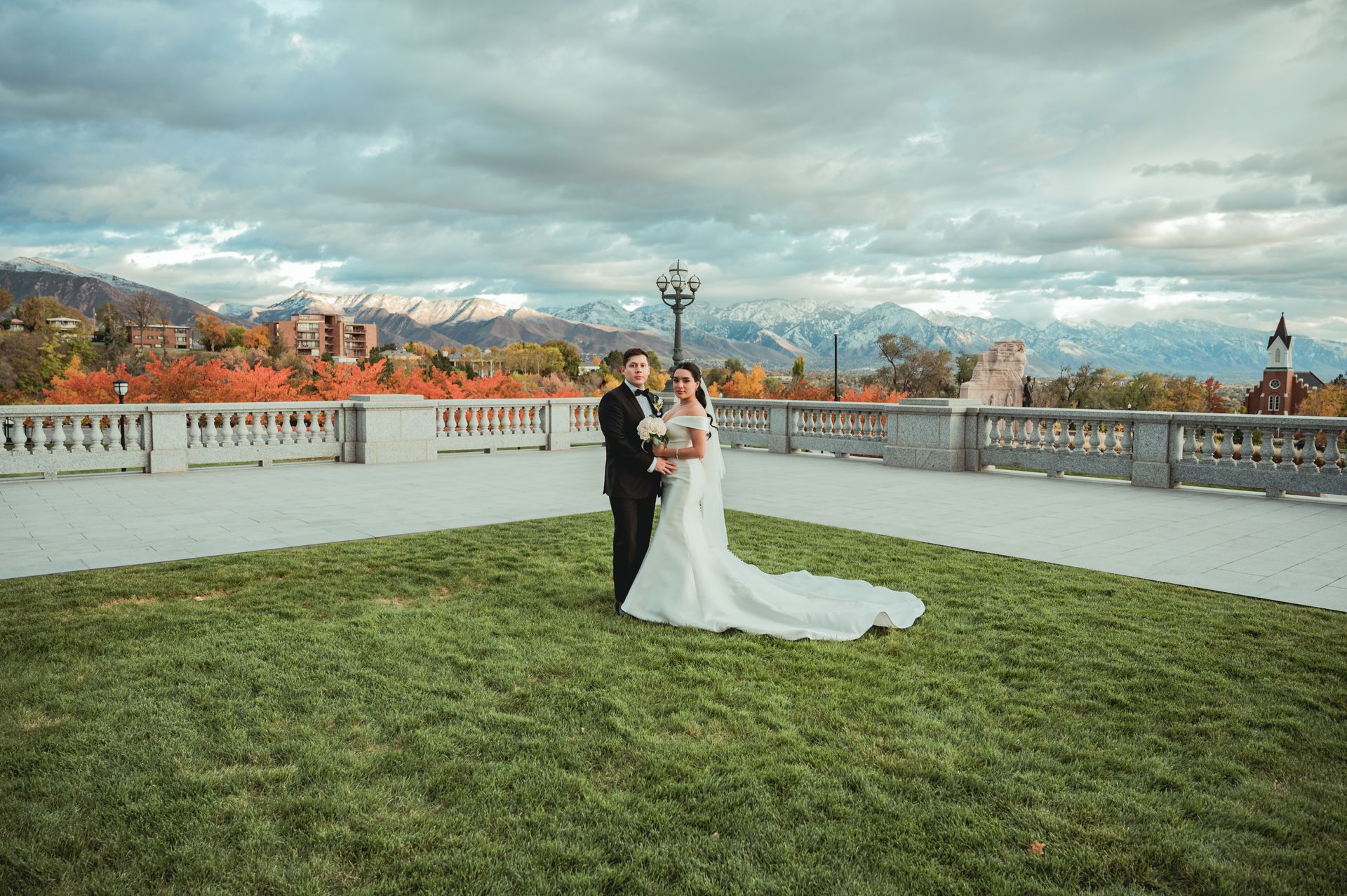 Bride and groom standing close together on green grass on their wedding day