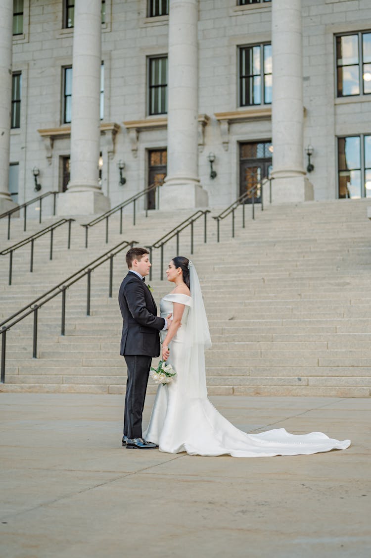 Newlyweds Standing At Bottom Of Stairs