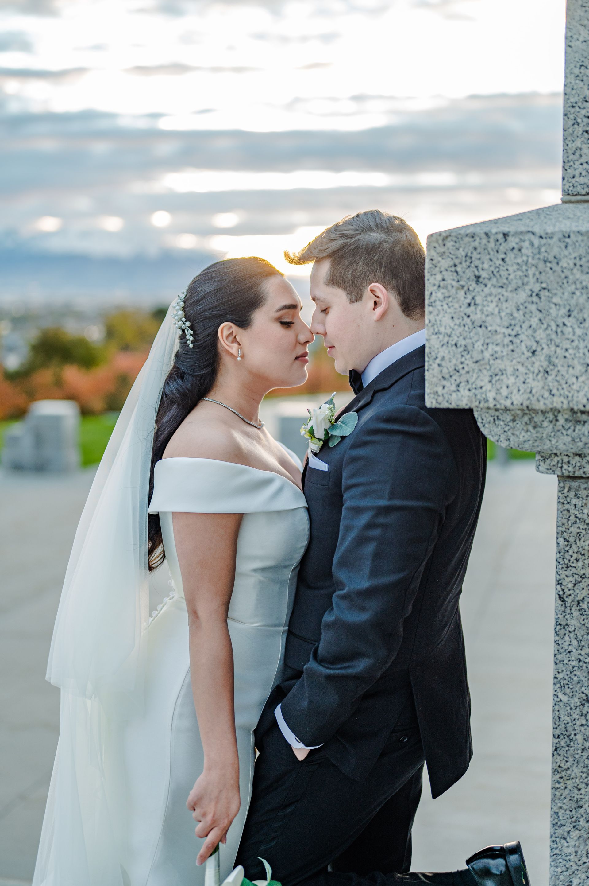 Bride and groom sharing a tender moment outdoors during their ceremony