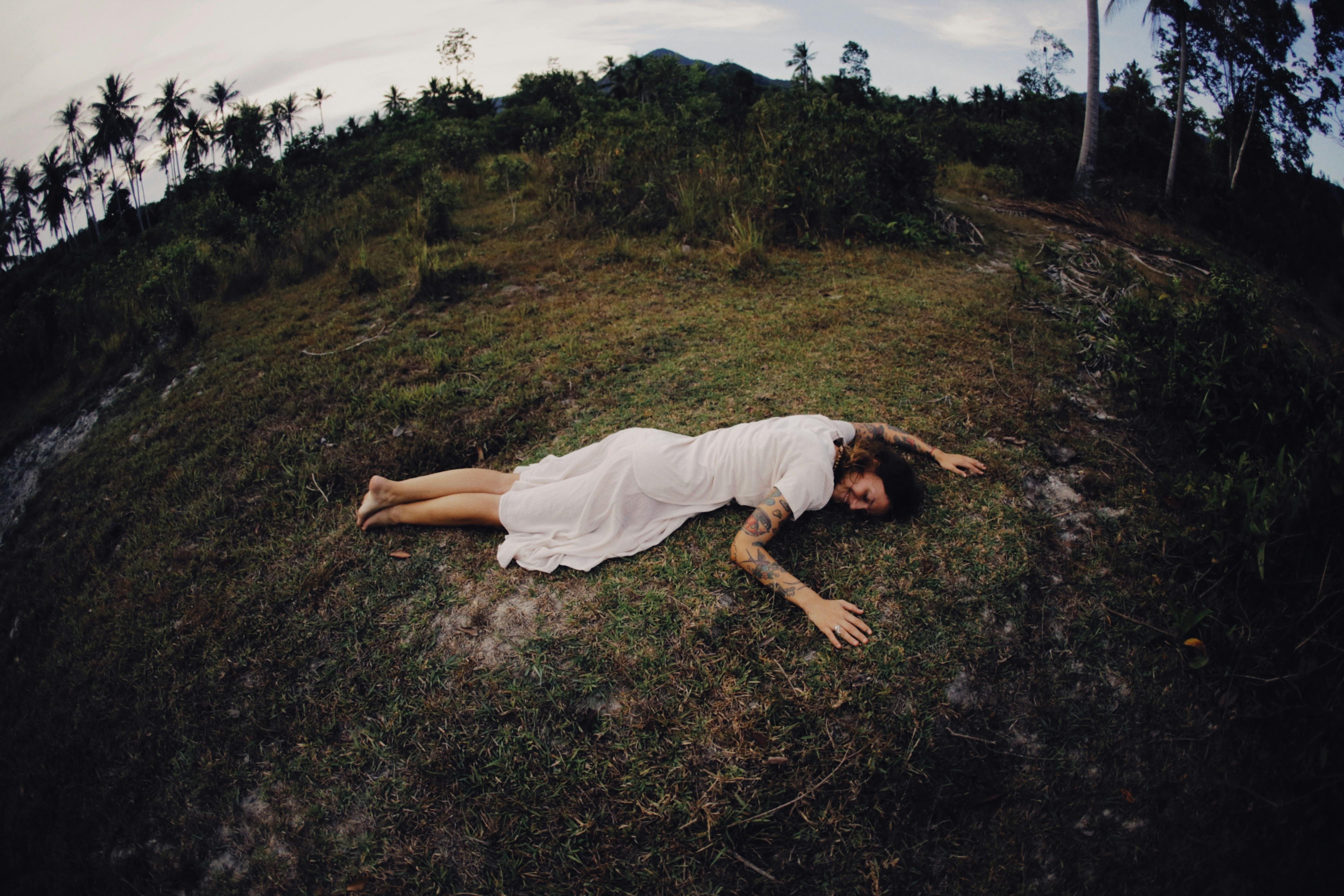 Young woman lying down in a field in a green dress, Stock Photo, Picture  And Royalty Free Image. Pic. SLR-IS0997Y2A