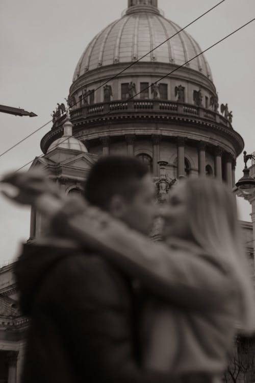 Couple Hugging with Building Dome in Background