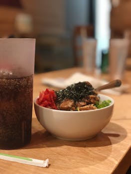 A vibrant Japanese dish accompanied by a refreshing drink on a wooden table, perfect for food lovers.