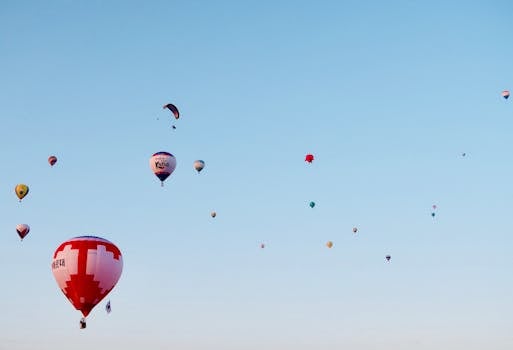 Colorful hot air balloons soaring high against a clear blue sky, symbolizing freedom and adventure.