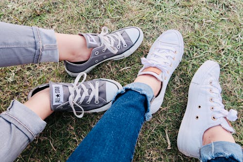 Gratis Dua Orang Mengenakan Sepatu Sneaker Low Top Converse Allstar Foto Stok