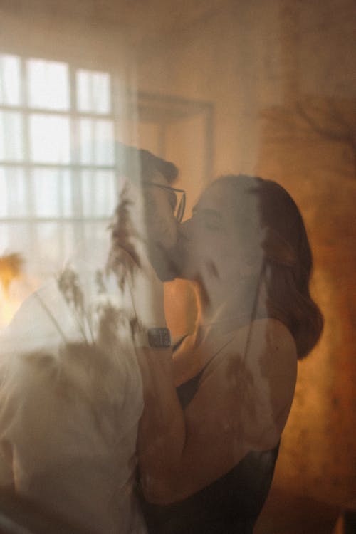 Couple Kissing with Love Seen Behind Glass Pane