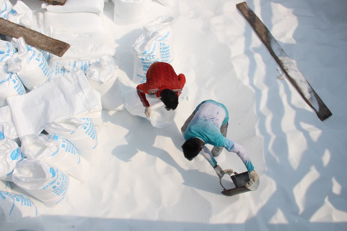men scooping salt into bags for pool