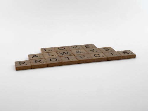 Close-Up Shot of Scrabble Tiles on White Surface