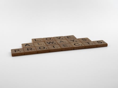Brown Wooden Scrabble Pieces on White Surface