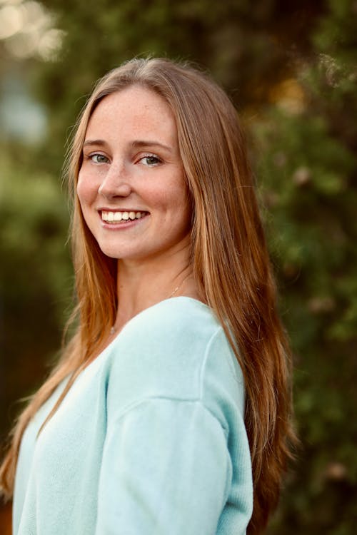 Smiling Woman in Blue Long Sleeve Shirt