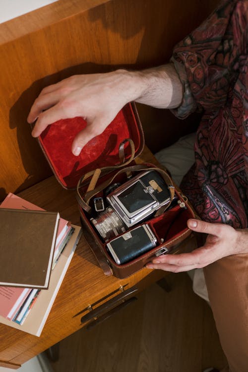 Unrecognizable Male Hands Opening Leather Box with Analog Camera Inside