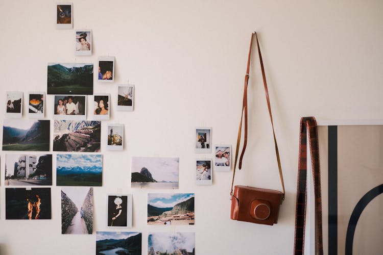 Polaroid Pictures And Vintage Photo Camera Hanging On Wall In Room