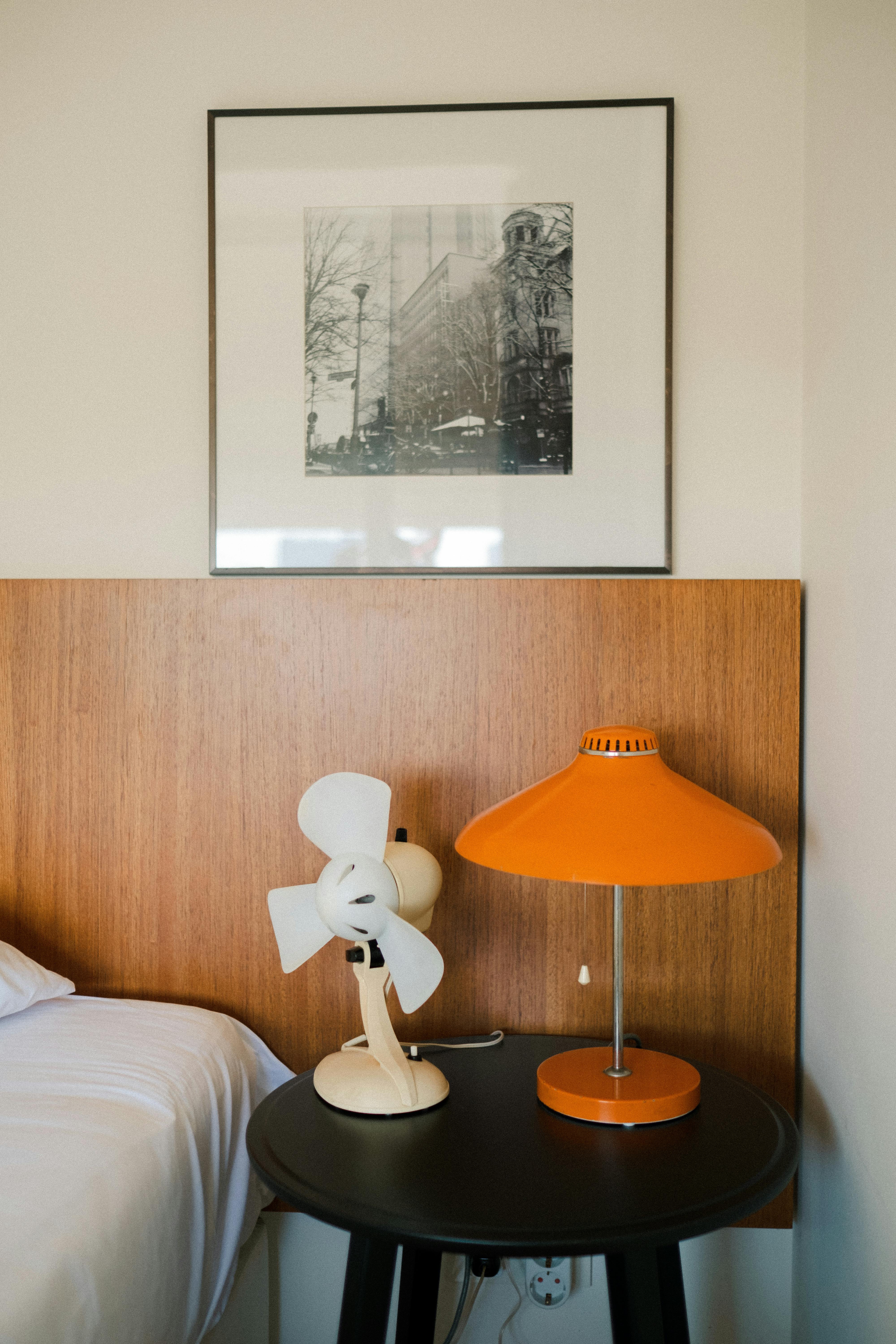 old fashioned fan and lamp on a table on a bedroom