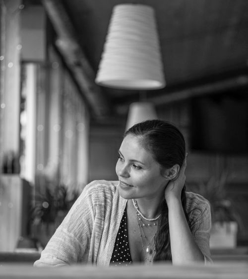 Free Black and white portrait of a smiling woman in a cozy cafe setting. Stock Photo