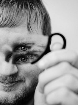 Unique portrait of a man holding a mirror reflecting multiple eyes, creating an artistic kaleidoscope effect.