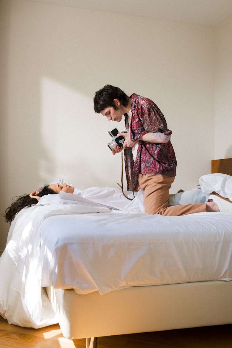 Man Filming Woman On Bed