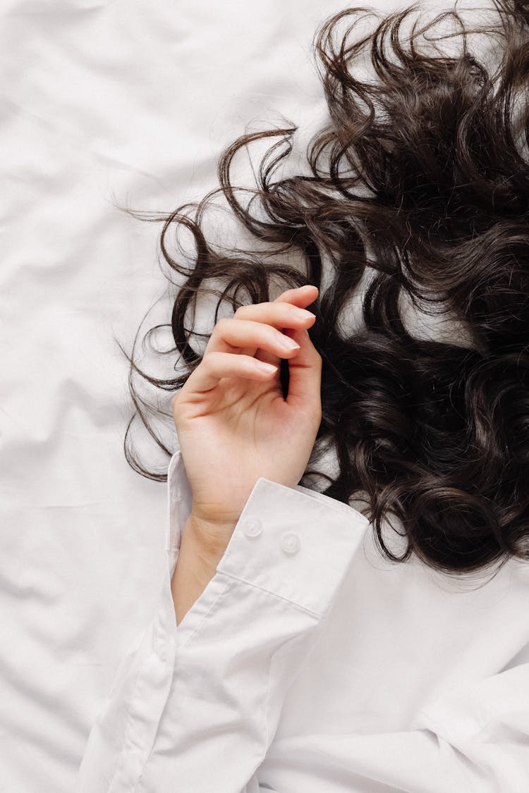 Woman Hand And Hair On Bed