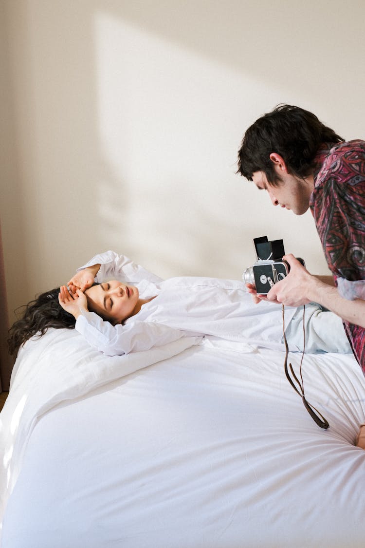 Man Filming Woman On Bed