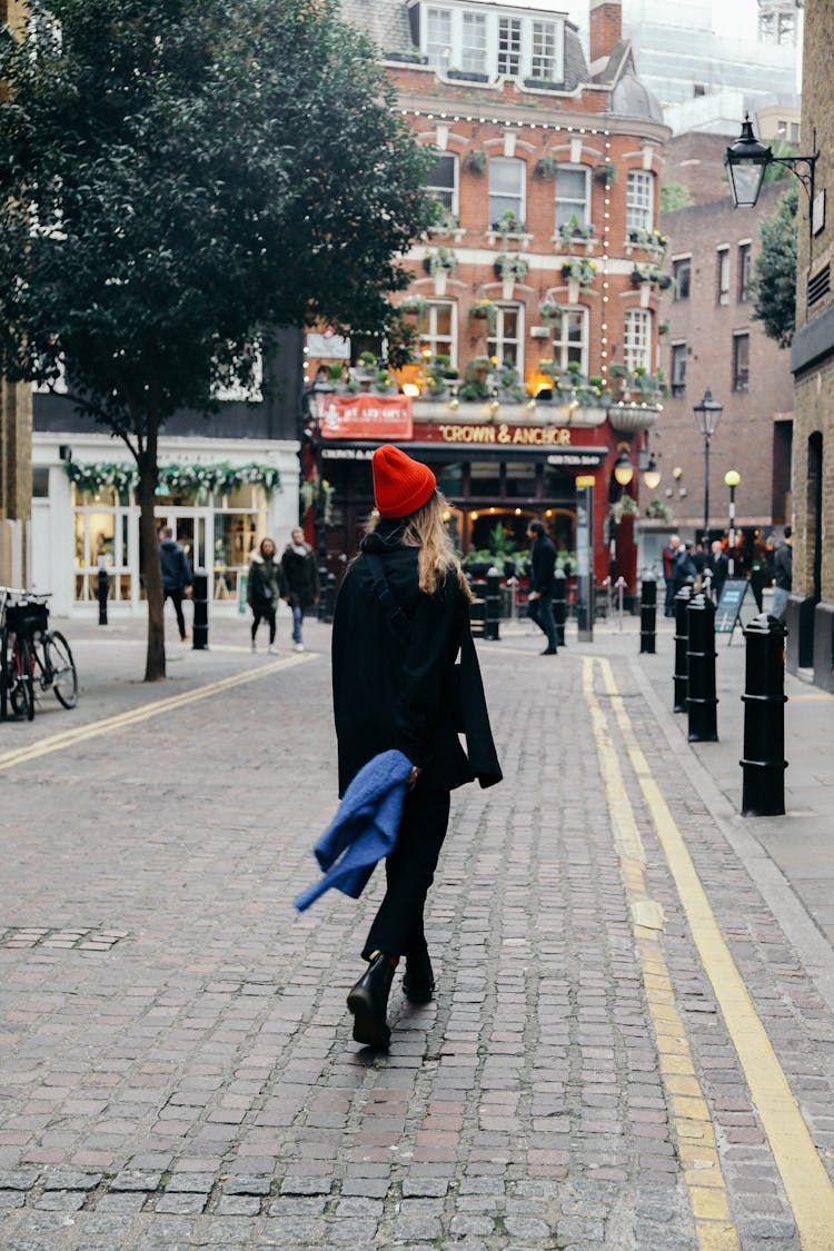 Back View Of Woman Walking On The Streets Of London, England 